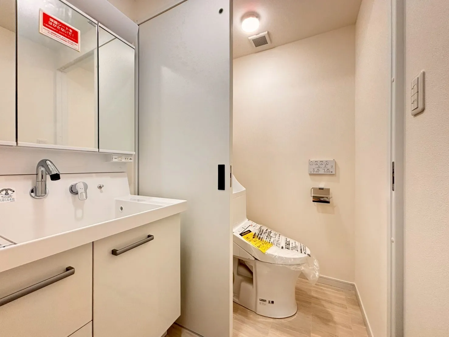洗面台とトイレがスライドドアで仕切られた形になっています。リフォーム済みのため洗面台とトイレはどちらも新品交換済みで気持ちよくお使いいただけます。