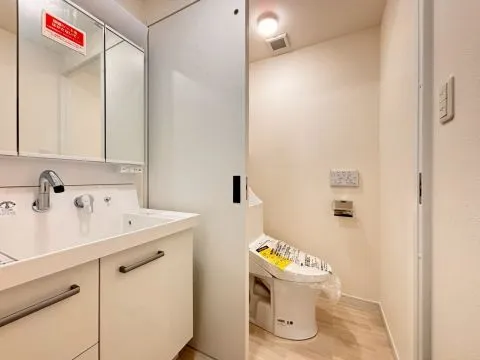 洗面台とトイレがスライドドアで仕切られた形になっています。リフォーム済みのため洗面台とトイレはどちらも新品交換済みで気持ちよくお使いいただけます。