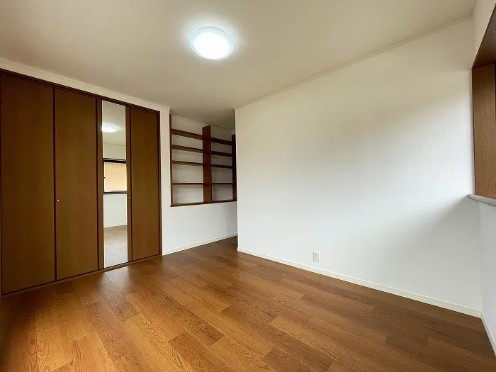 南東側約6.5帖の洋室です。こちらもバルコニーに出られるお部屋で、出入り口のデッドスペースには棚が作られており、スペースを有効活用しております。2面採光で明るいお部屋です。