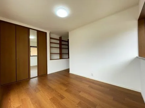 南東側約6.5帖の洋室です。こちらもバルコニーに出られるお部屋で、出入り口のデッドスペースには棚が作られており、スペースを有効活用しております。2面採光で明るいお部屋です。