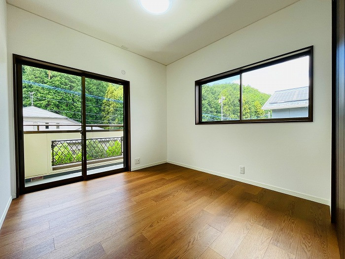 2階南西約5帖洋室。バルコニーに繋がるお部屋で、開口部が大きく明るい室内です。