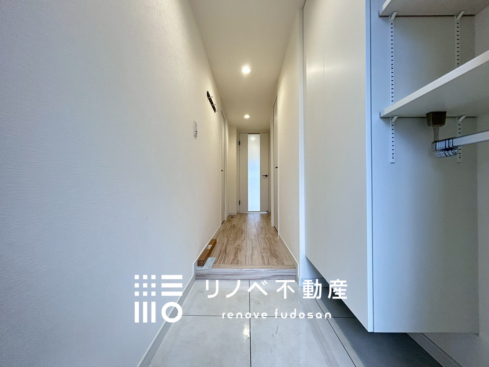 ダウンライトの柔らかな光が空間を引き立てる、落ち着いた雰囲気の玄関。収納力のあるシューズラックつきで、見た目もスッキリ