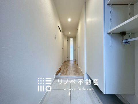 ダウンライトの柔らかな光が空間を引き立てる、落ち着いた雰囲気の玄関。収納力のあるシューズラックつきで、見た目もスッキリ