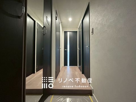 黒の建具とダウンライトが印象的な、落ち着いた雰囲気の玄関です。