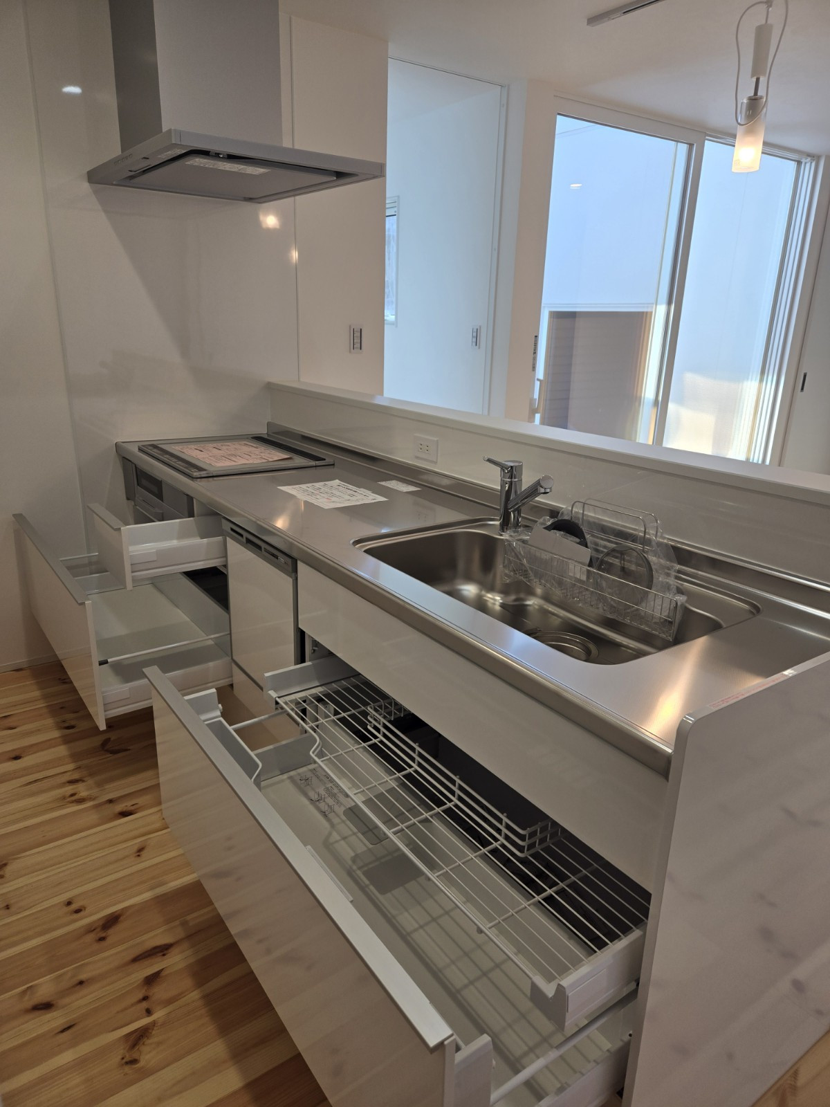 食洗器と収納力のある引き出しを完備したシステムキッチンです。窓の外のウッドデッキを眺めながら、気持ちよく家事ができます。