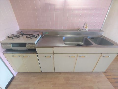 ピンクのタイル貼りで明るいキッチンです