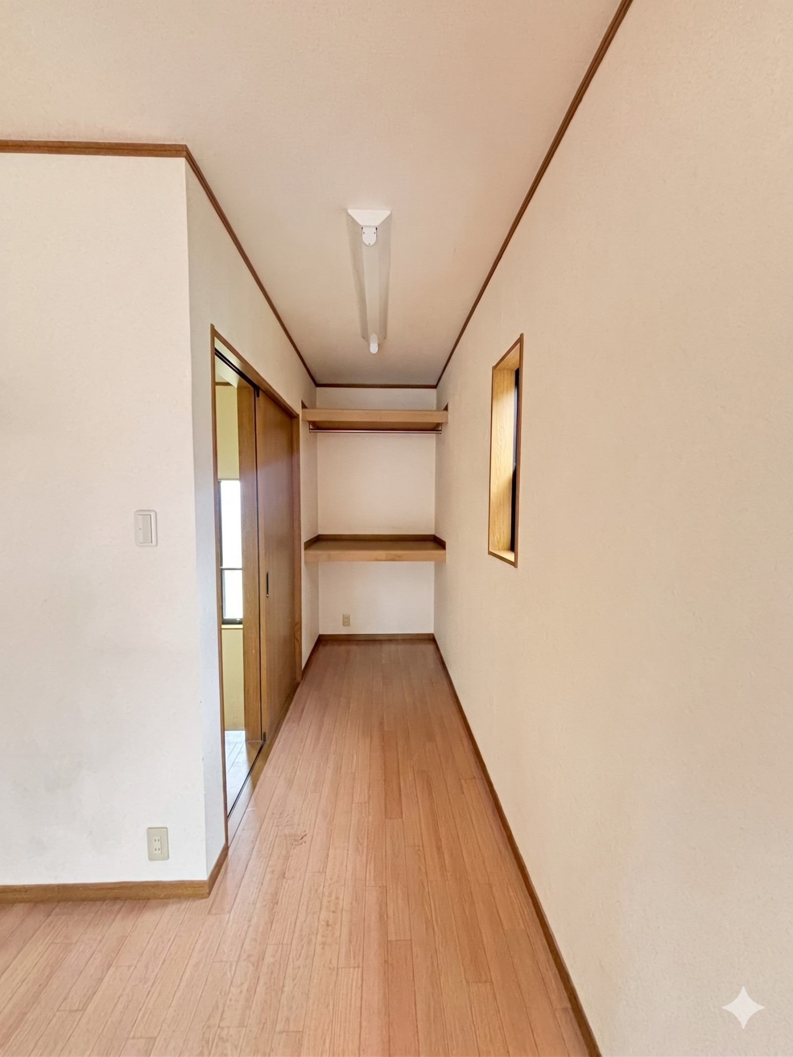 洋室３の奥まった位置に配置された収納エリア。ハンガーパイプと収納棚を備え、日用品やお子さまのおもちゃなどの整理に幅広く活躍します。