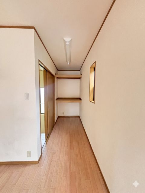 洋室３の奥まった位置に配置された収納エリア。ハンガーパイプと収納棚を備え、日用品やお子さまのおもちゃなどの整理に幅広く活躍します。