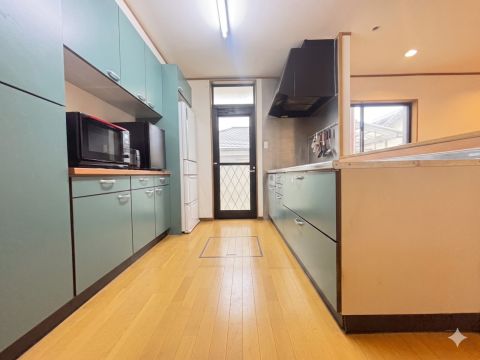 落ち着いたブルーグリーンのキッチンパネルがアクセント。複数人でも作業しやすいワイドなキッチン通路。実際に見学してこの広さを確かめてください！