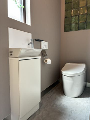 グリーンタイルが映える、スタイリッシュなトイレ空間です。