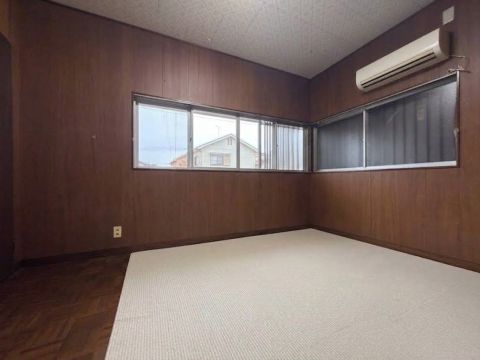 ６帖洋室。レトロな木目調の壁が魅力の室内です。※ＡＩにより、室内の家財道具を除去して掲載しています。